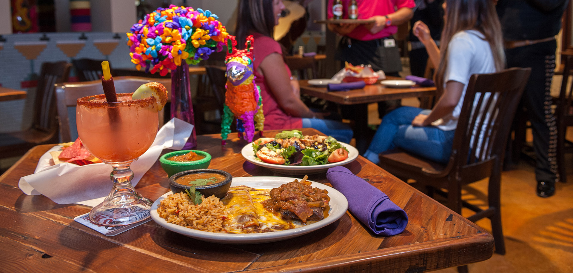 A waitress holds up a margarita in front of Cafe Ole at the San Antonio Riverwalk